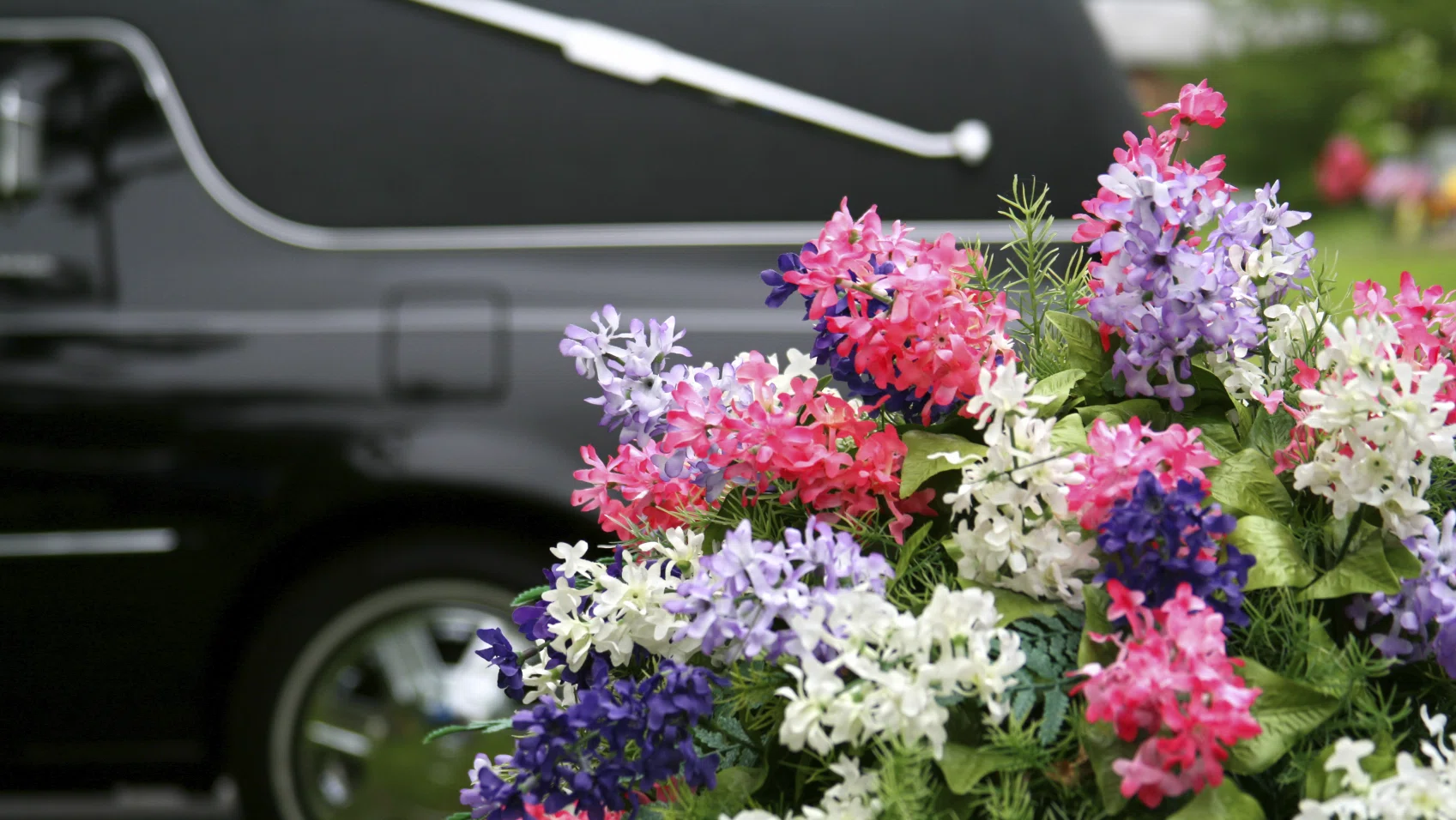 Rouwauto met bloemstuk