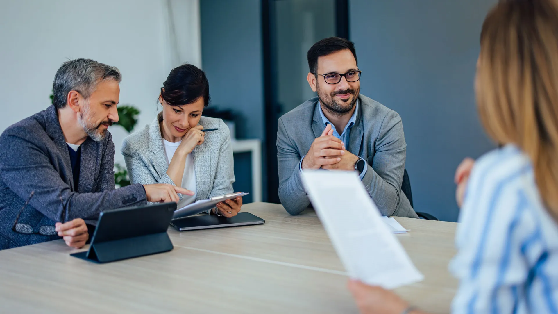 Vier collega's om tafel met elkaar in overleg