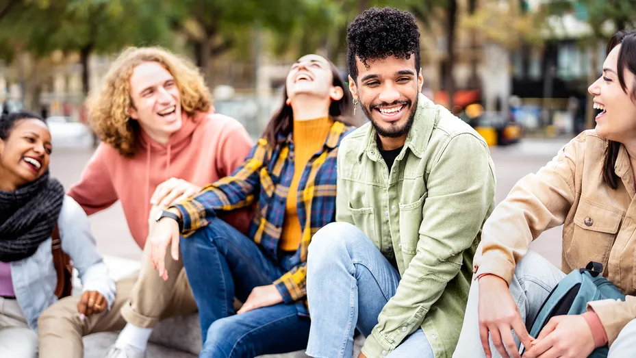 Groep jongeren met verschillende uiterlijke kenmerken lachen samen