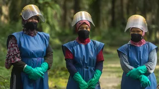 Indonesia palmoil women workers on a plantation wearing protective equipment when spraying pesticides