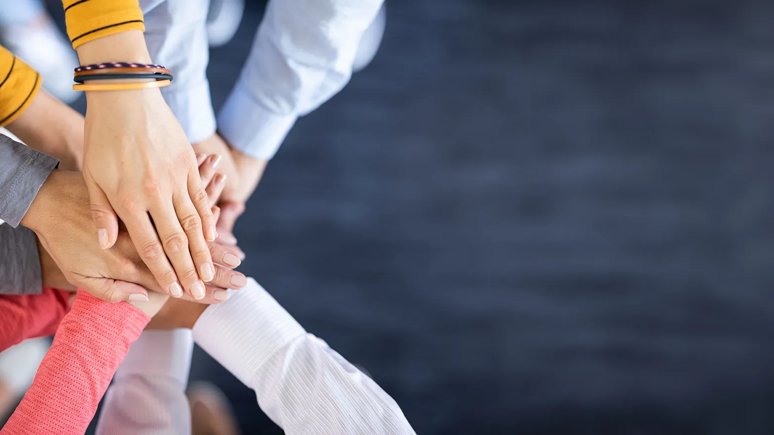 Diverse handen bij elkaar als één team