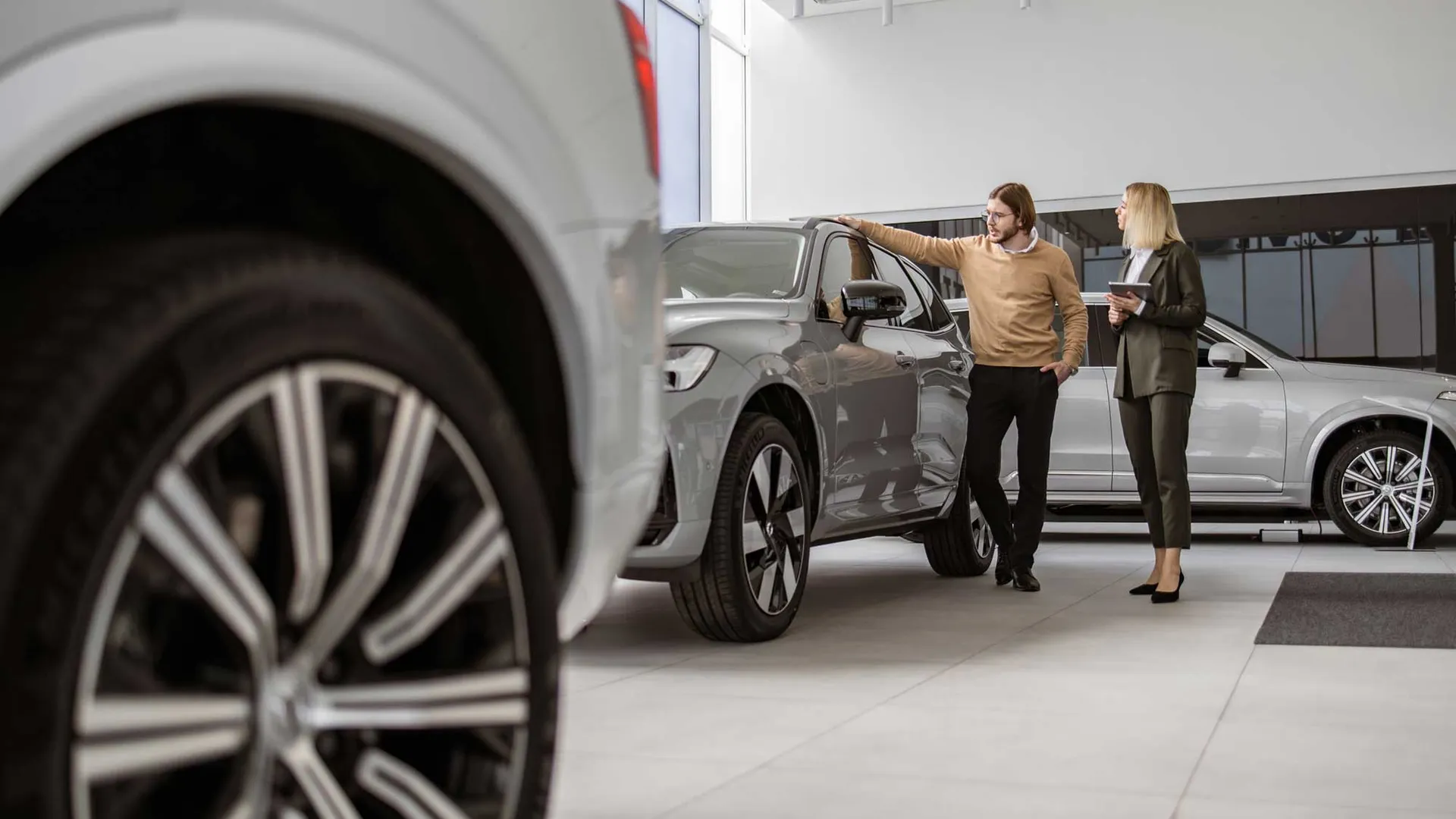 Twee mensen bekijken een auto in de showroom