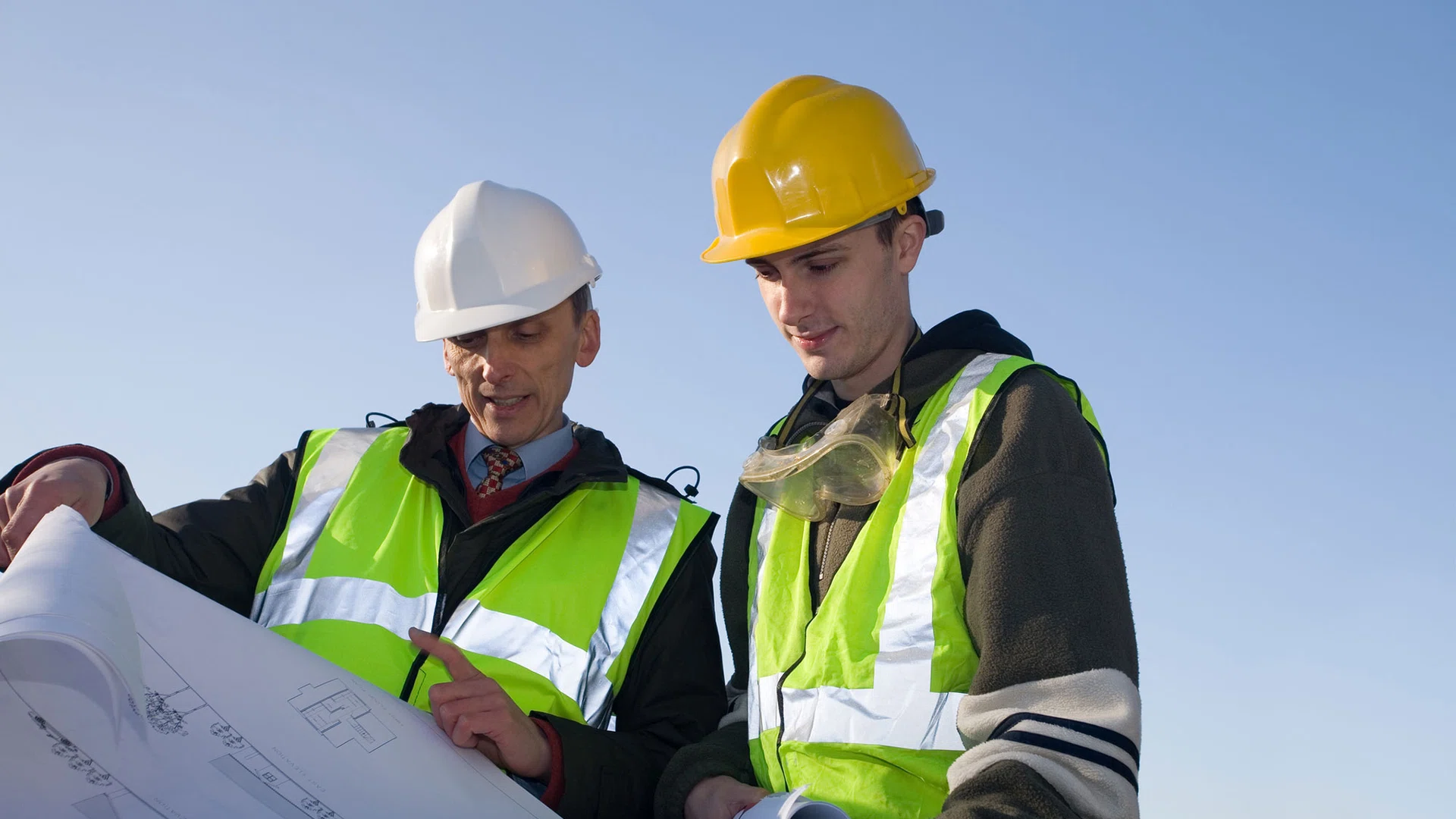 Twee bouwvakkers bekijken de werktekening