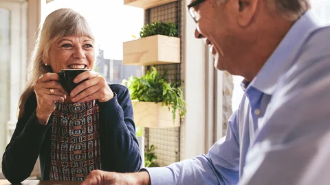 Man en vrouw, senioren, in gesprek aan de keukentafel