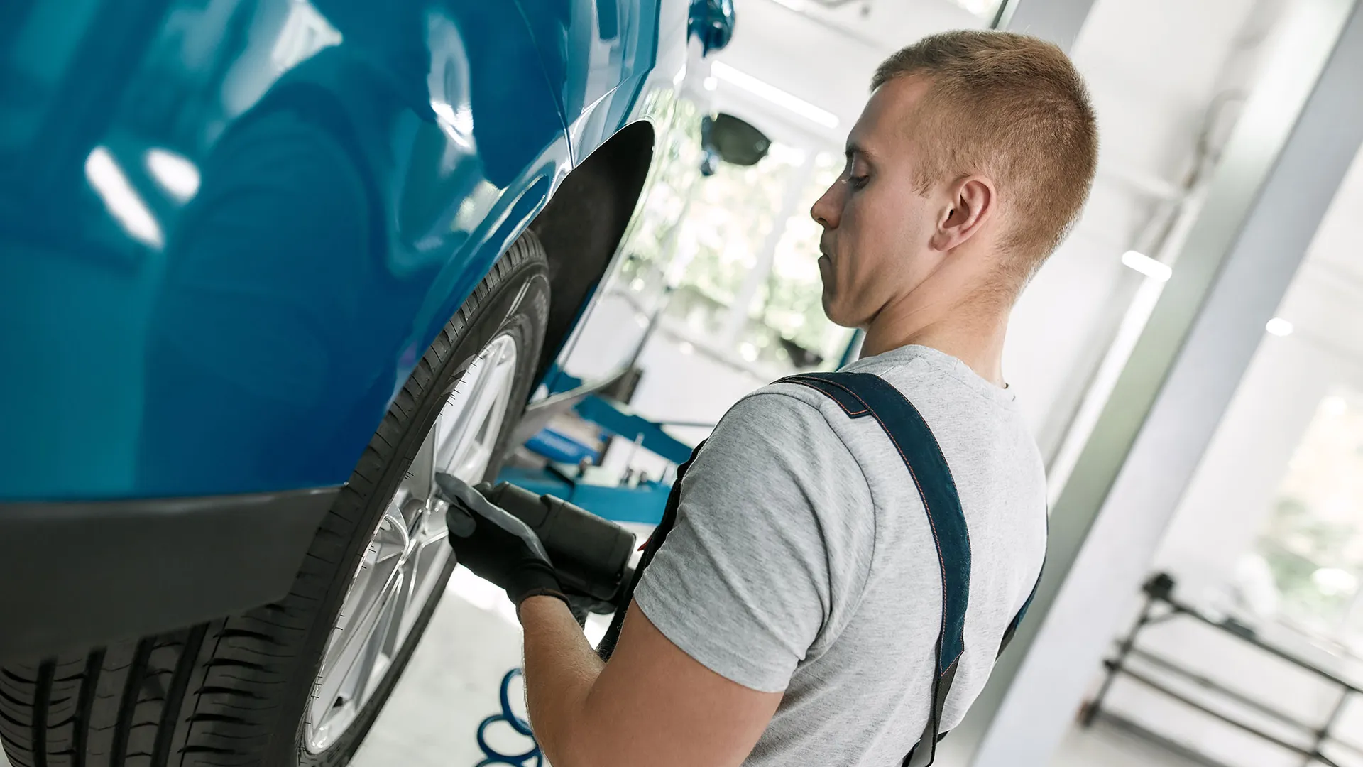 Monteur schroeft een band aan de auto