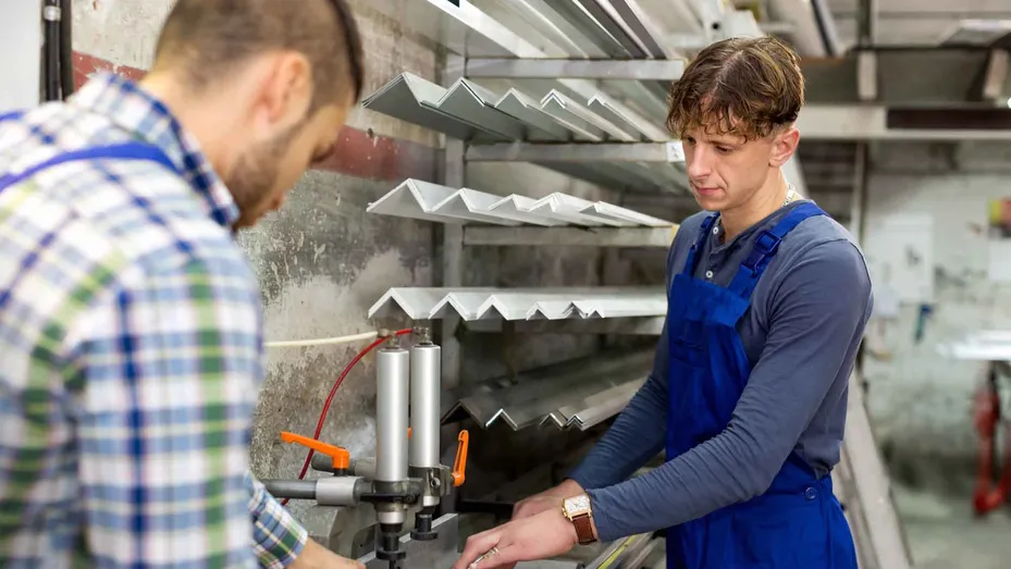 Twee metaalarbeiders werken aan aluminiumprofielen