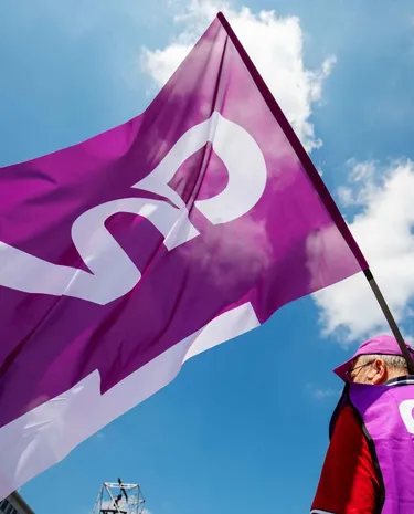 Man met actiehesje en CNV vlag in zijn handen