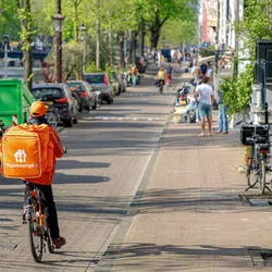 Fietskoerier van Thuisbezorgd aan het werk onderweg in de stad.