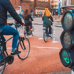 Fietsers voor het groene licht bij een druk kruispunt in de stad.