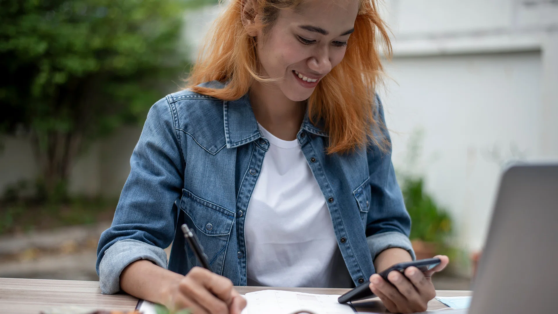 Vrouw met laptop en mobiel plant haar vakantiedagen in